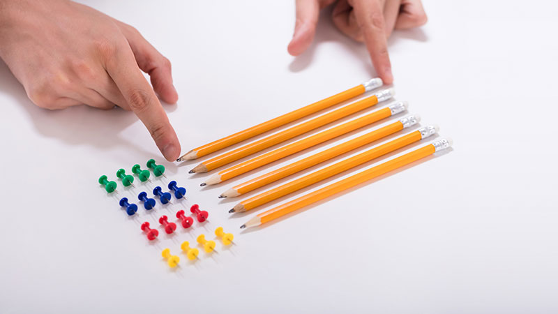 Pencils and push pins on table.
